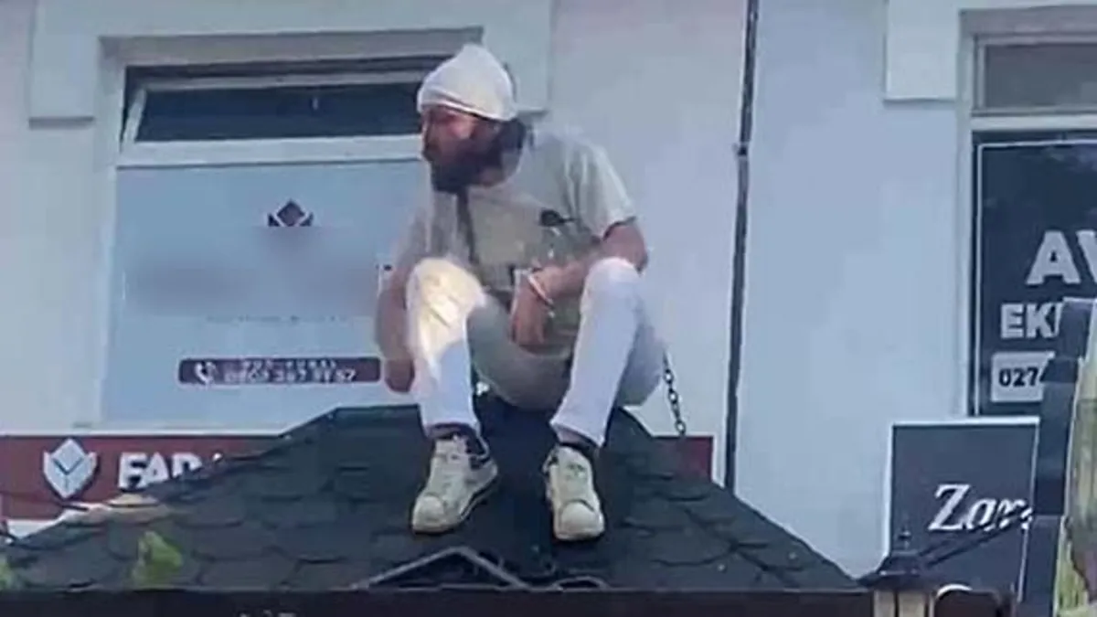 Kütahya'da hareketli anlar: Ekipleri görünce kendini çatıya zincirledi