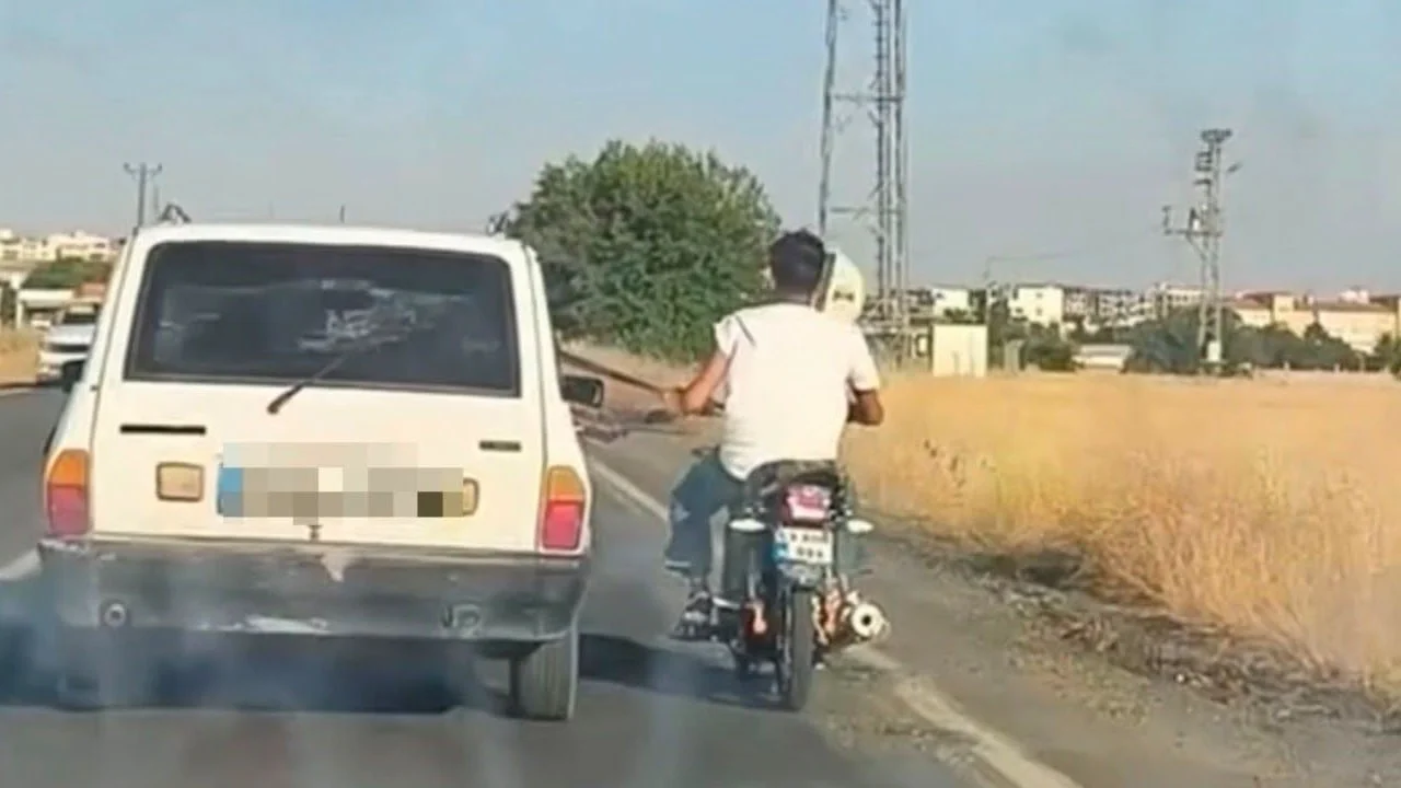 Trafikte akılalmaz yolculuk! Motosikletli emniyet kemerine tutunup böyle ilerledi