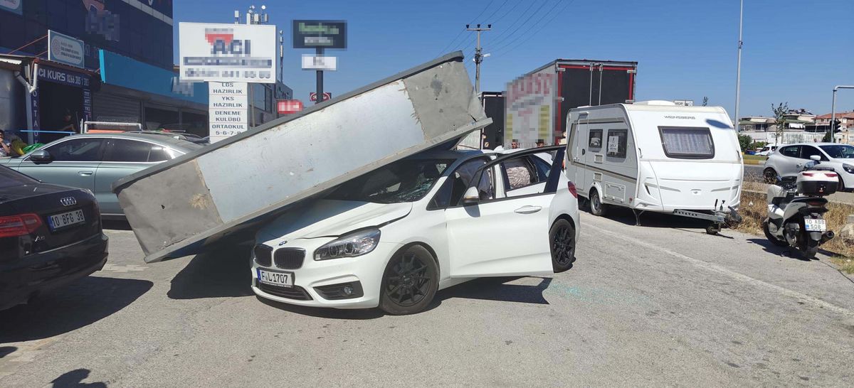 Üzerine reklam totemi devrilen otomobilin sürücüsü yara almadan kurtuldu