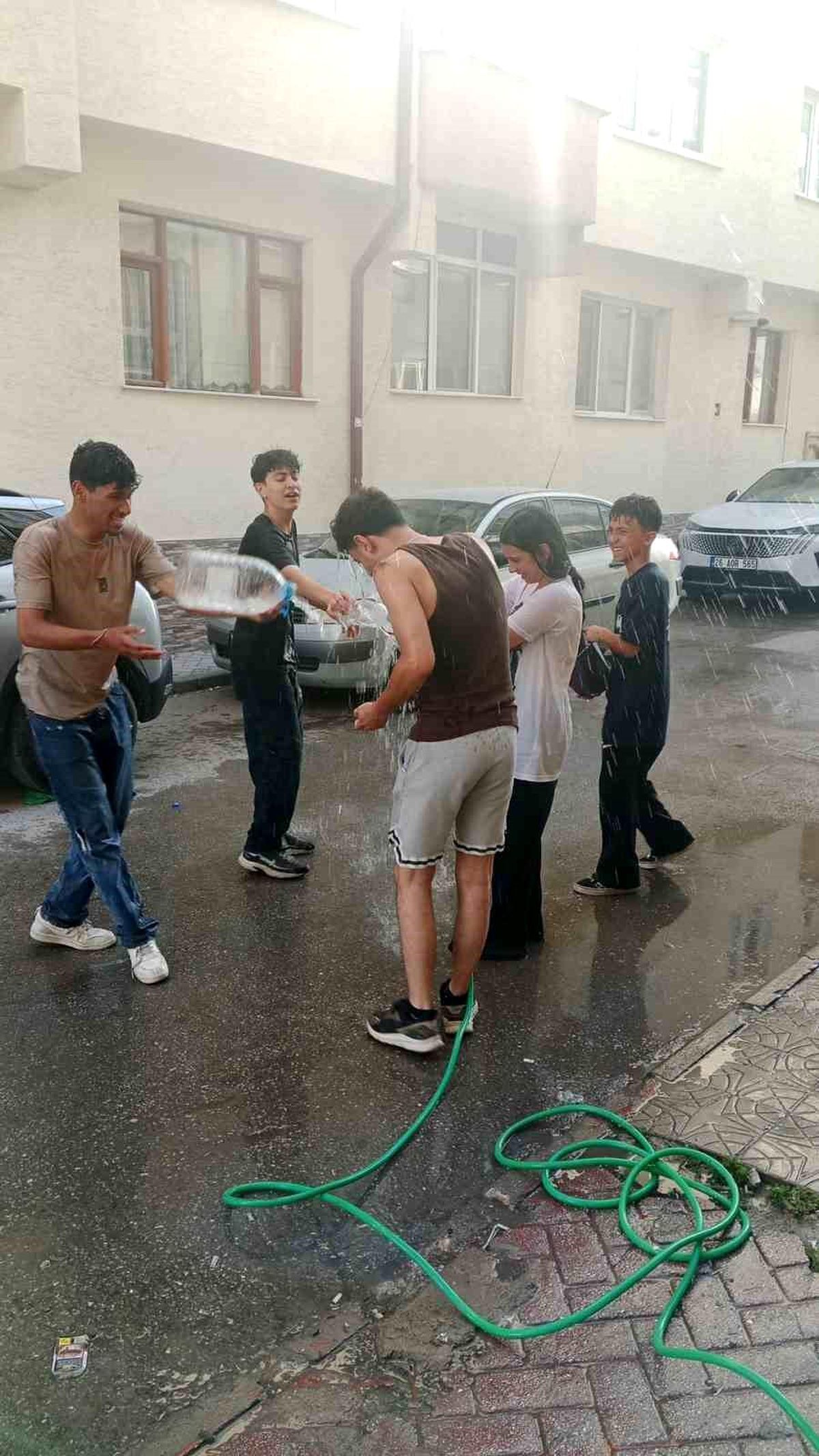 Sıcaktan bunalan gençler serinlemek için su savaşı yaptı