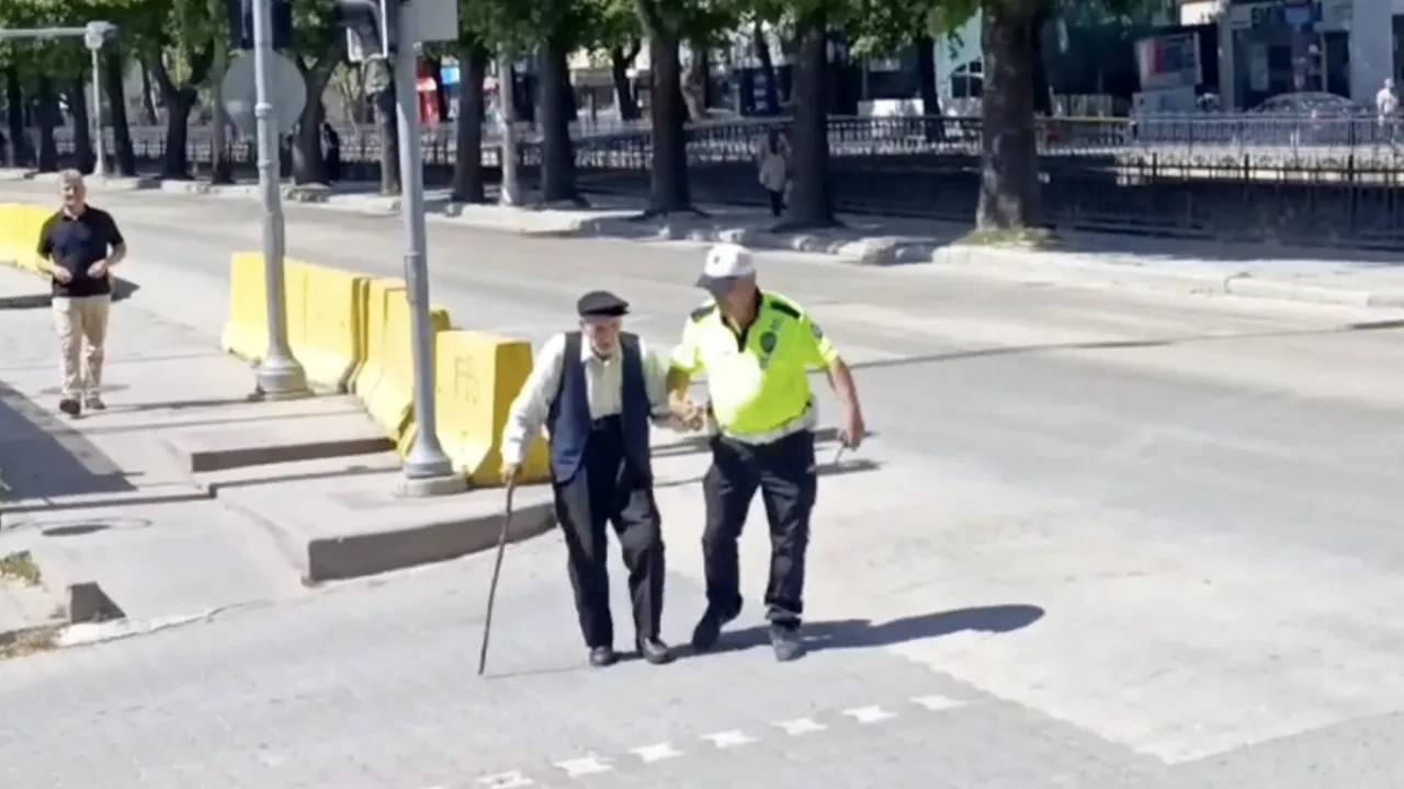 Trafik polisinin yürümekte zorlanan yaşlı adama yardımı yürekleri ısıttı