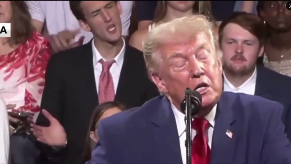 Seçmenlere hitap eden Trump'ın arkasına oturan bir kişi, Trump taklidi yaparak başkanla dalga geçti