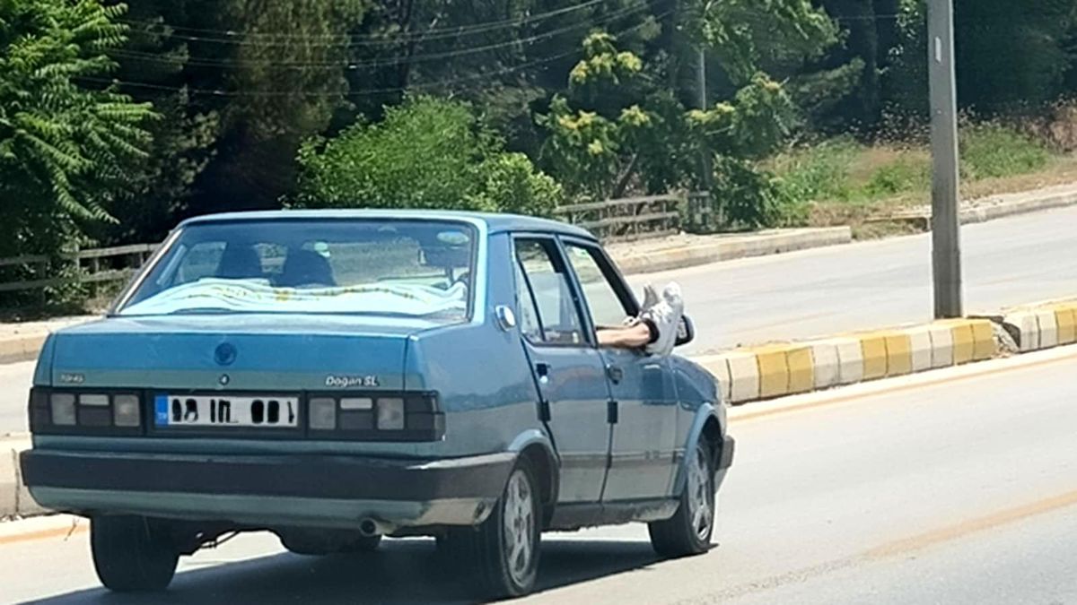 Ayaklarını camdan dışarı çıkartan yolcu trafiği riske attı